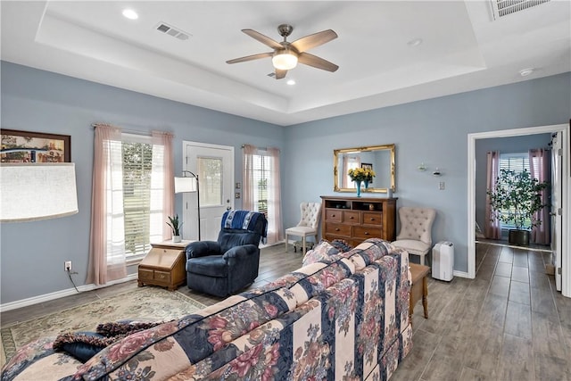 living room with plenty of natural light and a tray ceiling