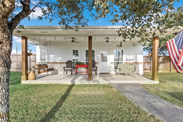 rear view of house with a lawn, ceiling fan, and a patio area