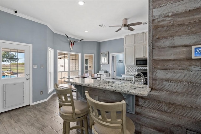 kitchen with a breakfast bar area, a healthy amount of sunlight, light wood-type flooring, and appliances with stainless steel finishes