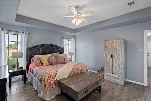 bedroom with hardwood / wood-style floors, multiple windows, and ceiling fan