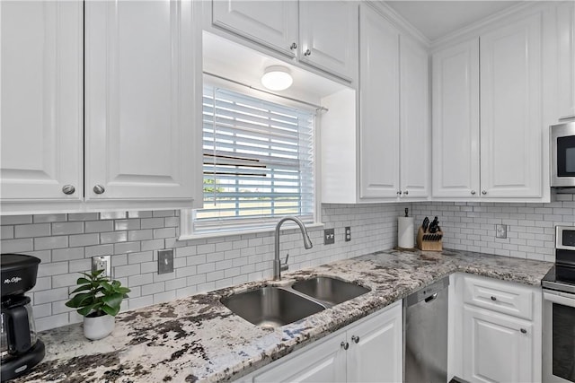 kitchen featuring sink, light stone countertops, tasteful backsplash, white cabinetry, and stainless steel appliances