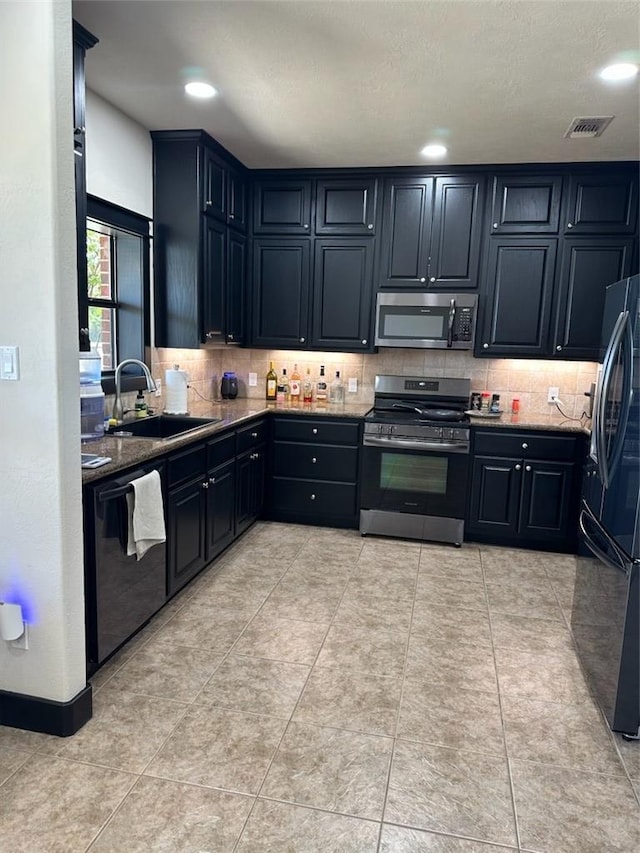 kitchen with decorative backsplash, sink, light tile patterned floors, and stainless steel appliances