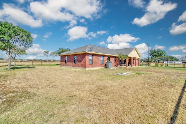 rear view of property with a yard and central AC