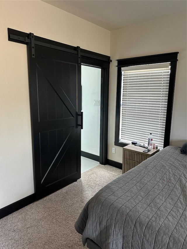 carpeted bedroom featuring a barn door