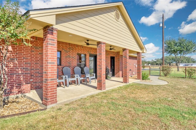 rear view of house with a patio area, ceiling fan, and a yard