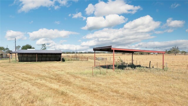 view of yard featuring a rural view and an outdoor structure