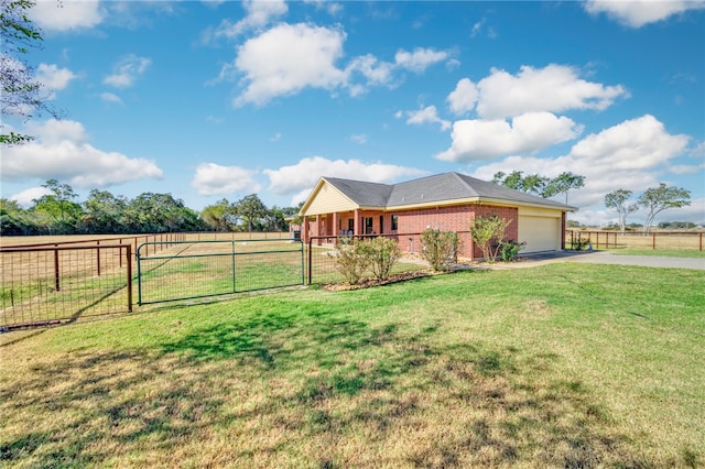 view of front facade with a garage, a rural view, and a front yard