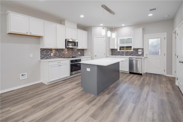507 Brosig Ave, Navasota, TX 77868 - kitchen with stainless steel appliances, backsplash, light countertops, white cabinets, and recessed lighting