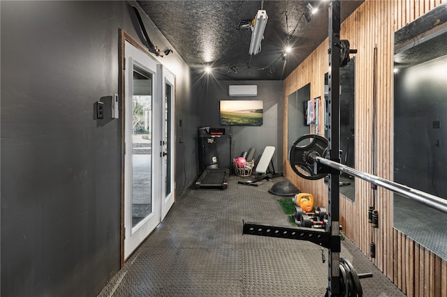 exercise room featuring dark colored carpet and an AC wall unit