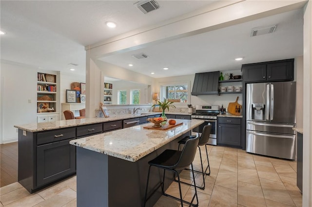 kitchen featuring visible vents, a kitchen island, light stone counters, appliances with stainless steel finishes, and open shelves