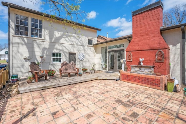 back of property featuring a wooden deck and a patio