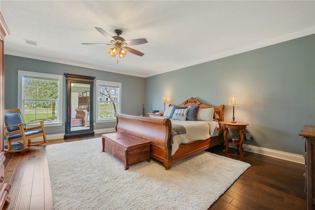 bedroom featuring visible vents, crown molding, ceiling fan, baseboards, and hardwood / wood-style flooring