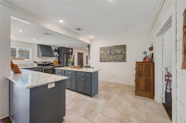 kitchen with visible vents, gray cabinetry, appliances with stainless steel finishes, light stone countertops, and extractor fan