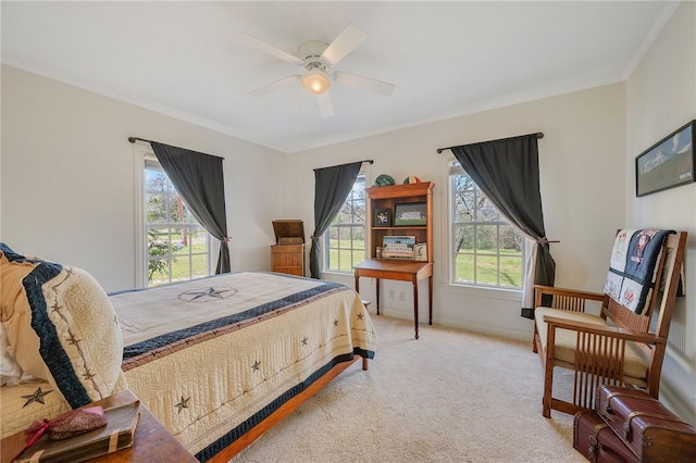 bedroom featuring light colored carpet, baseboards, crown molding, and a ceiling fan