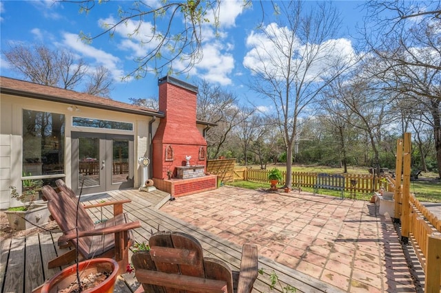 view of patio / terrace featuring french doors, a fireplace, and fence