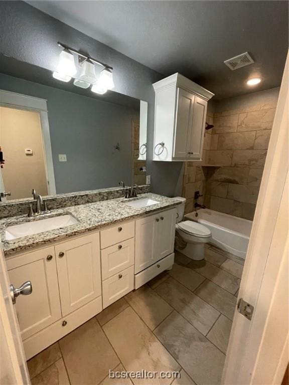 full bathroom featuring tiled shower / bath, tile patterned floors, vanity, and toilet