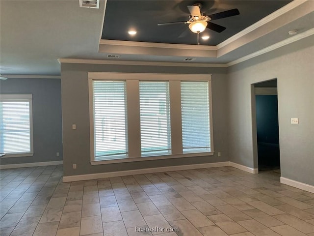 unfurnished room featuring ceiling fan, light hardwood / wood-style floors, ornamental molding, and a tray ceiling