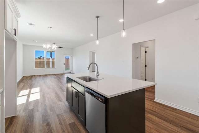 kitchen featuring stainless steel dishwasher, a kitchen island with sink, sink, dark hardwood / wood-style floors, and hanging light fixtures