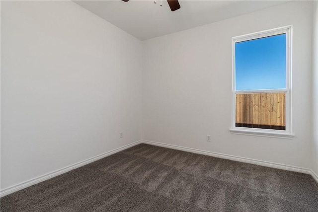 empty room with dark carpet and ceiling fan