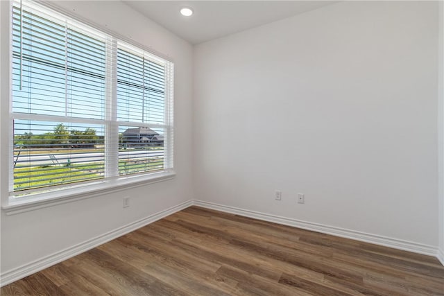 empty room with plenty of natural light and dark wood-type flooring