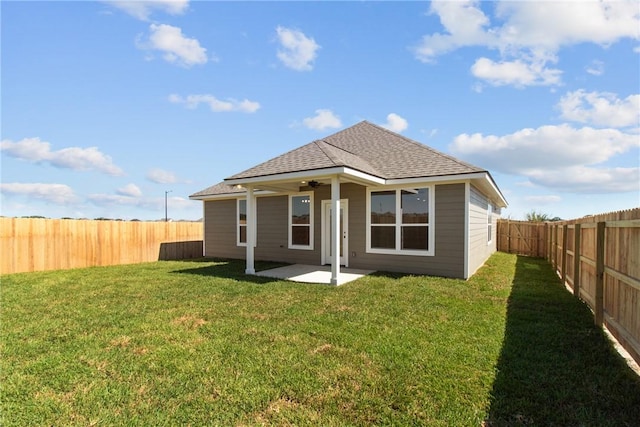 rear view of house featuring ceiling fan, a patio area, and a yard