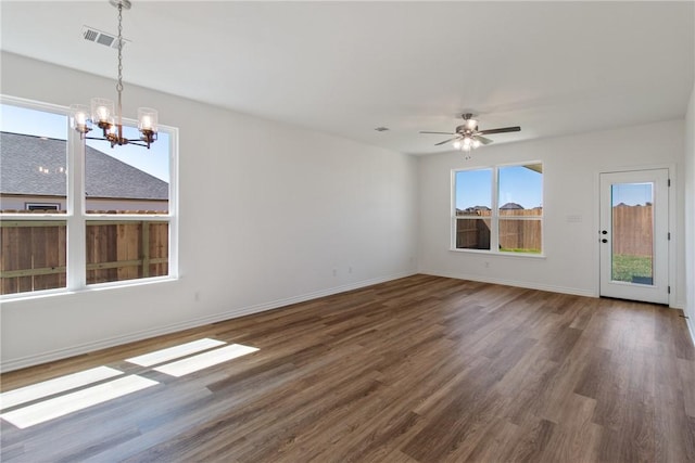 unfurnished living room featuring ceiling fan with notable chandelier and dark hardwood / wood-style floors