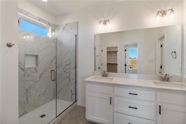 bathroom featuring tile patterned floors, vanity, a healthy amount of sunlight, and a shower with shower door