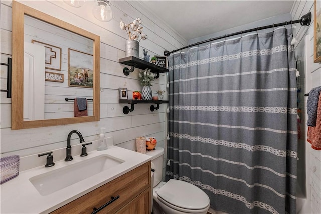 bathroom with vanity, wood walls, toilet, and walk in shower