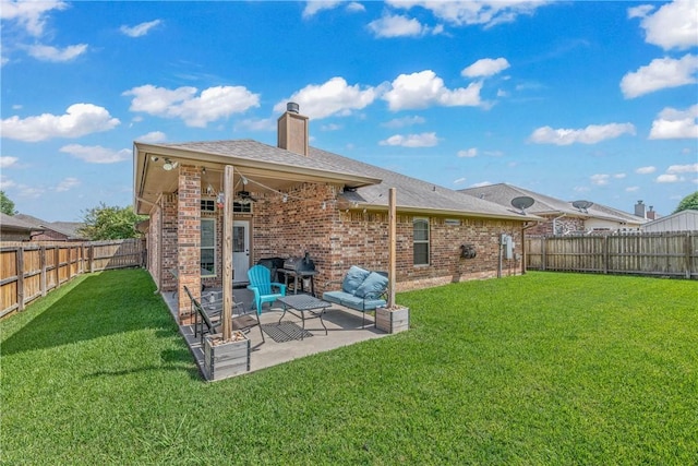 rear view of property featuring a yard, a patio, and ceiling fan