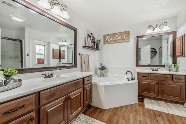 bathroom with separate shower and tub, hardwood / wood-style floors, and vanity