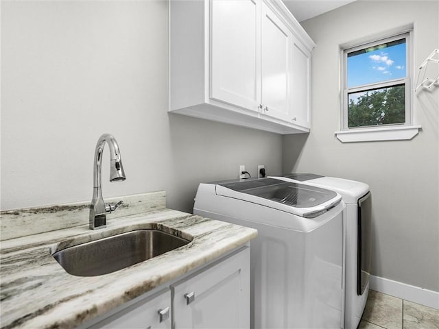 washroom featuring cabinets, independent washer and dryer, light tile patterned floors, and sink