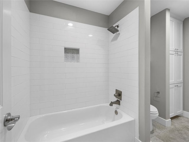 bathroom with toilet and tiled shower / bath