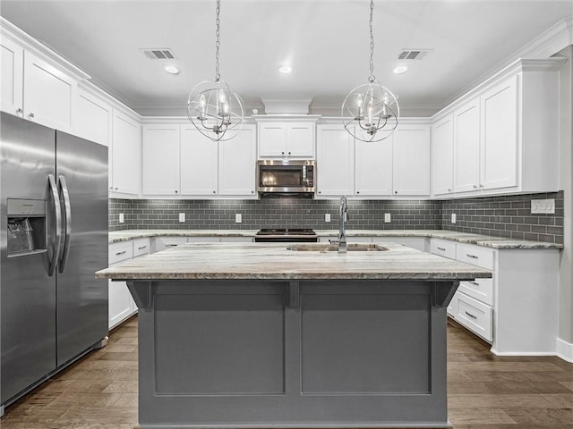 kitchen featuring white cabinets, an island with sink, and appliances with stainless steel finishes