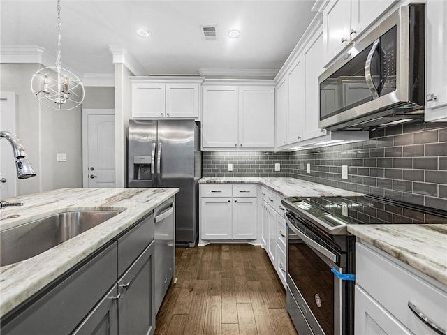 kitchen with sink, white cabinets, stainless steel appliances, and ornamental molding