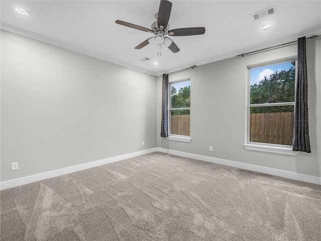 carpeted empty room with ceiling fan and ornamental molding