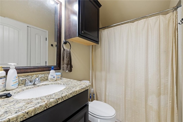 bathroom with a shower with shower curtain, vanity, and toilet