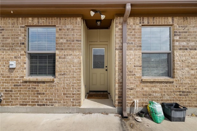 doorway to property with brick siding