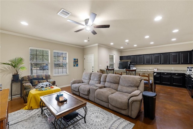 living area with baseboards, visible vents, crown molding, concrete flooring, and recessed lighting