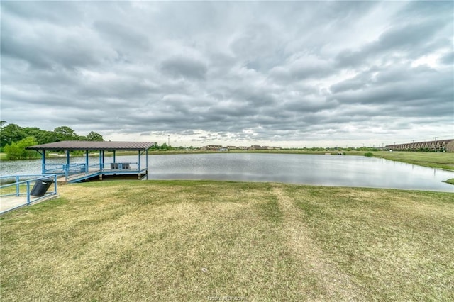 dock area with a water view and a lawn