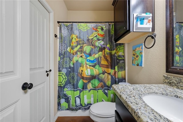 full bath with toilet, a textured wall, a shower with shower curtain, and vanity