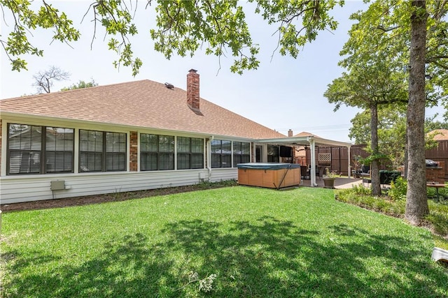 3003 Aztec St, College Station, TX 77845 - back of house featuring a hot tub, a chimney, a shingled roof, and a patio area