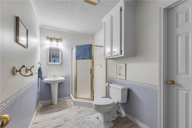 3003 Aztec St, College Station, TX 77845 - bathroom with ornamental molding, toilet, wood finished floors, a shower stall, and a sink