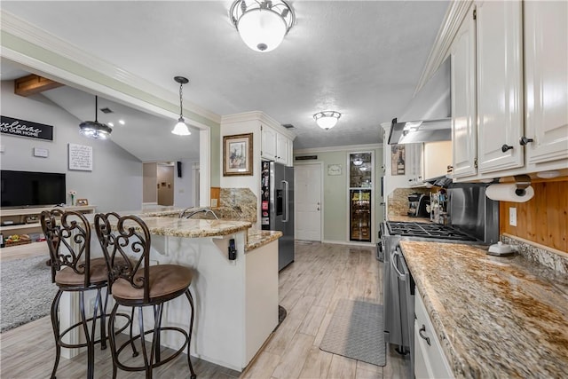 3003 Aztec St, College Station, TX 77845 - kitchen featuring appliances with stainless steel finishes, a kitchen breakfast bar, a peninsula, decorative backsplash, and light wood-style floors