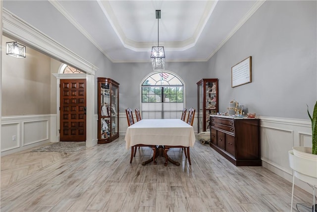 3003 Aztec St, College Station, TX 77845 - dining area featuring a tray ceiling, a decorative wall, light wood finished floors, wainscoting, and crown molding