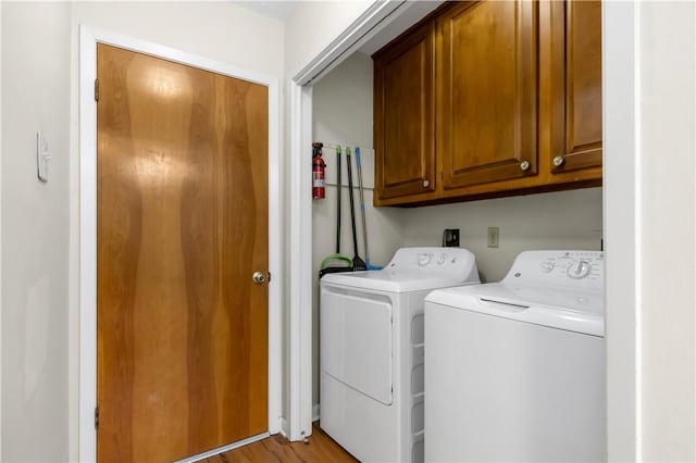 2306 Windsor Dr, Bryan, TX 77802 - laundry area featuring cabinet space, washing machine and clothes dryer, and light wood-style flooring