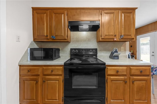 2306 Windsor Dr, Bryan, TX 77802 - kitchen featuring black appliances, extractor fan, light countertops, and tasteful backsplash