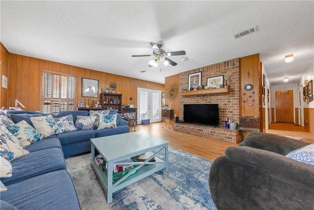 2306 Windsor Dr, Bryan, TX 77802 - living area with wood finished floors, ceiling fan, a brick fireplace, and wood walls