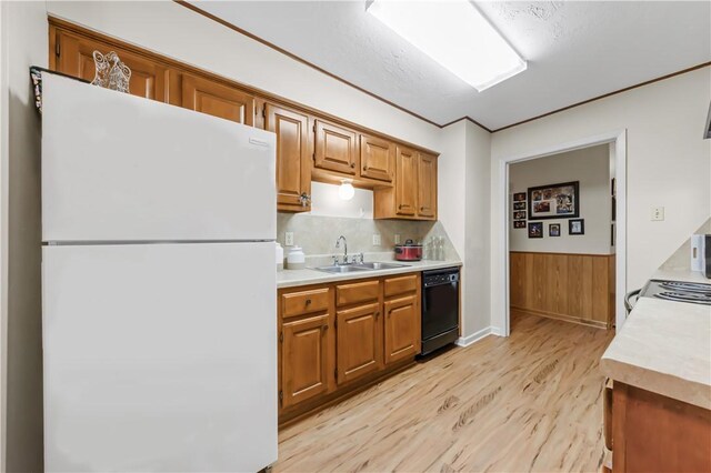 2306 Windsor Dr, Bryan, TX 77802 - kitchen featuring white appliances, light wood finished floors, light countertops, brown cabinets, and wainscoting
