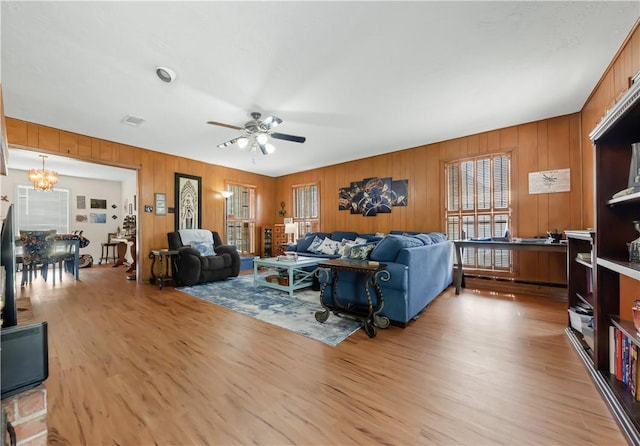 2306 Windsor Dr, Bryan, TX 77802 - living area with a ceiling fan, light wood-style floors, a chandelier, and wooden walls