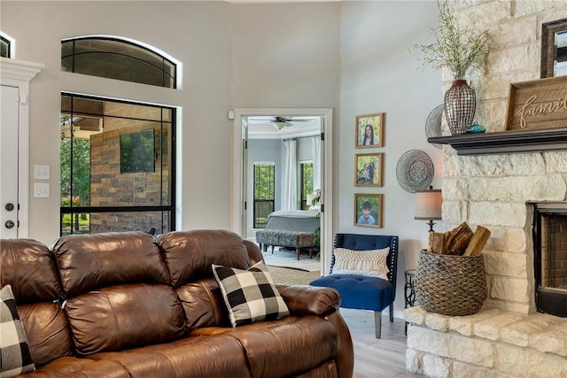5249 Drake Dr, College Station, TX 77845 - living area with plenty of natural light, a fireplace, a high ceiling, a ceiling fan, and light wood-type flooring